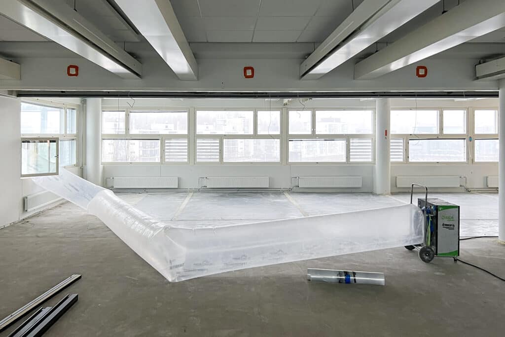 Toimistotila, jossa takaseinä ikkunaa, purettuna betonille.